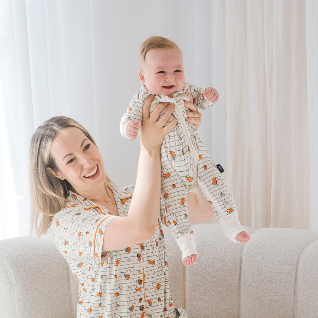 Baby iført ZIPSTER x Miffy Ternet Bloom bambus-babyheldragt