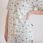 Frau, die das Damen-Pyjama-Set Miffy „Checkered Bloom“ aus Bambus trägt