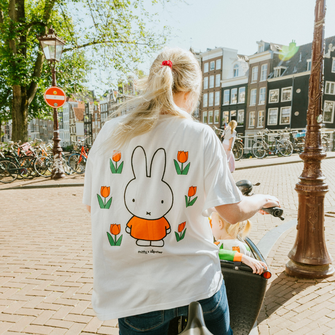 Vrouw die het nijntje witte borstvoeding-T-shirt draagt met een geborduurde tulp en borstvoedingsritsen