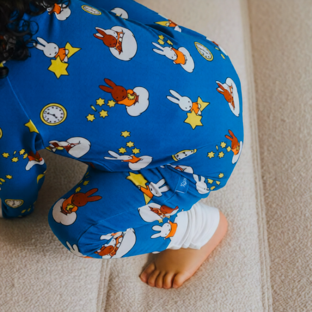 Baby iført ZIPSTER x Miffy Starry Sleep-bambus-sovdragt