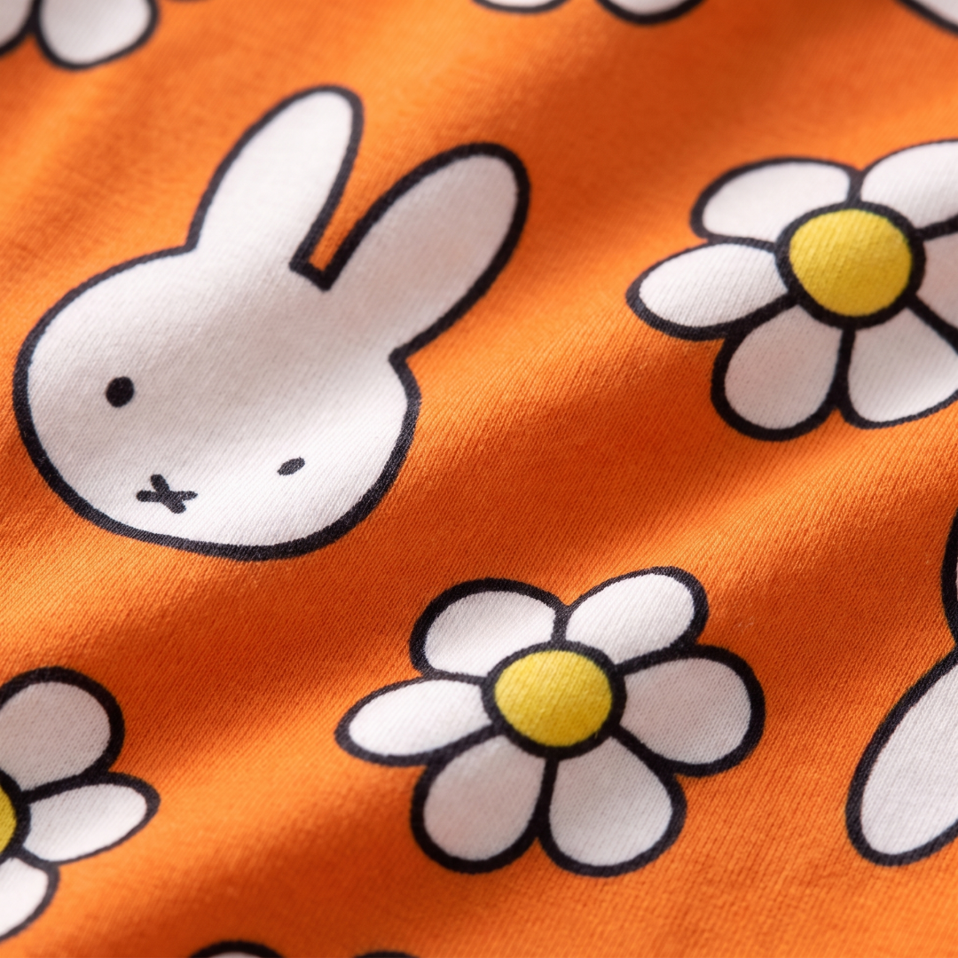 Close-up of the soft bamboo fabric of the ZIPSTER x Miffy Daisy Days bamboo babygrow